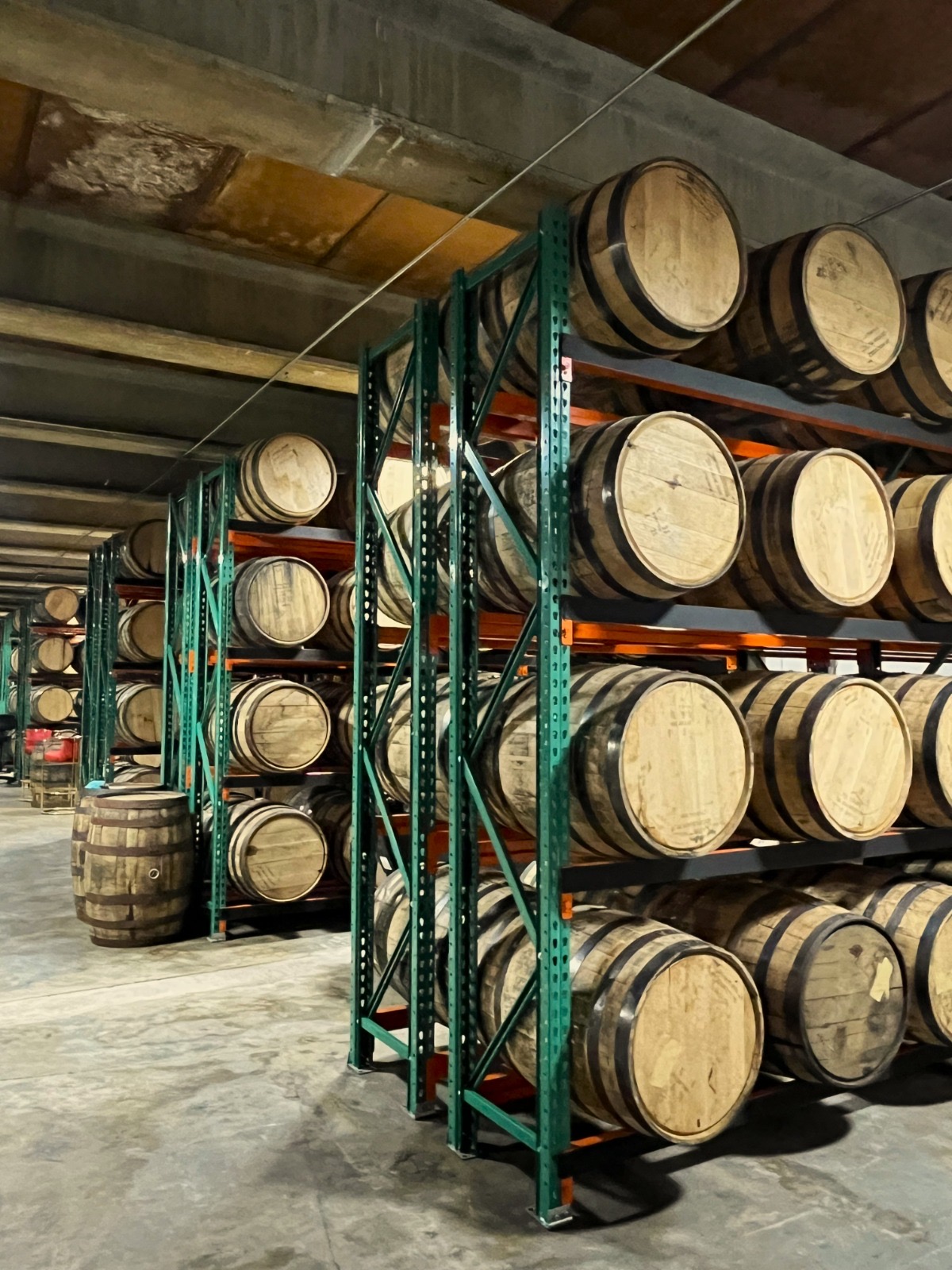 Rows of rum barrels aging inside Little River Distillery
